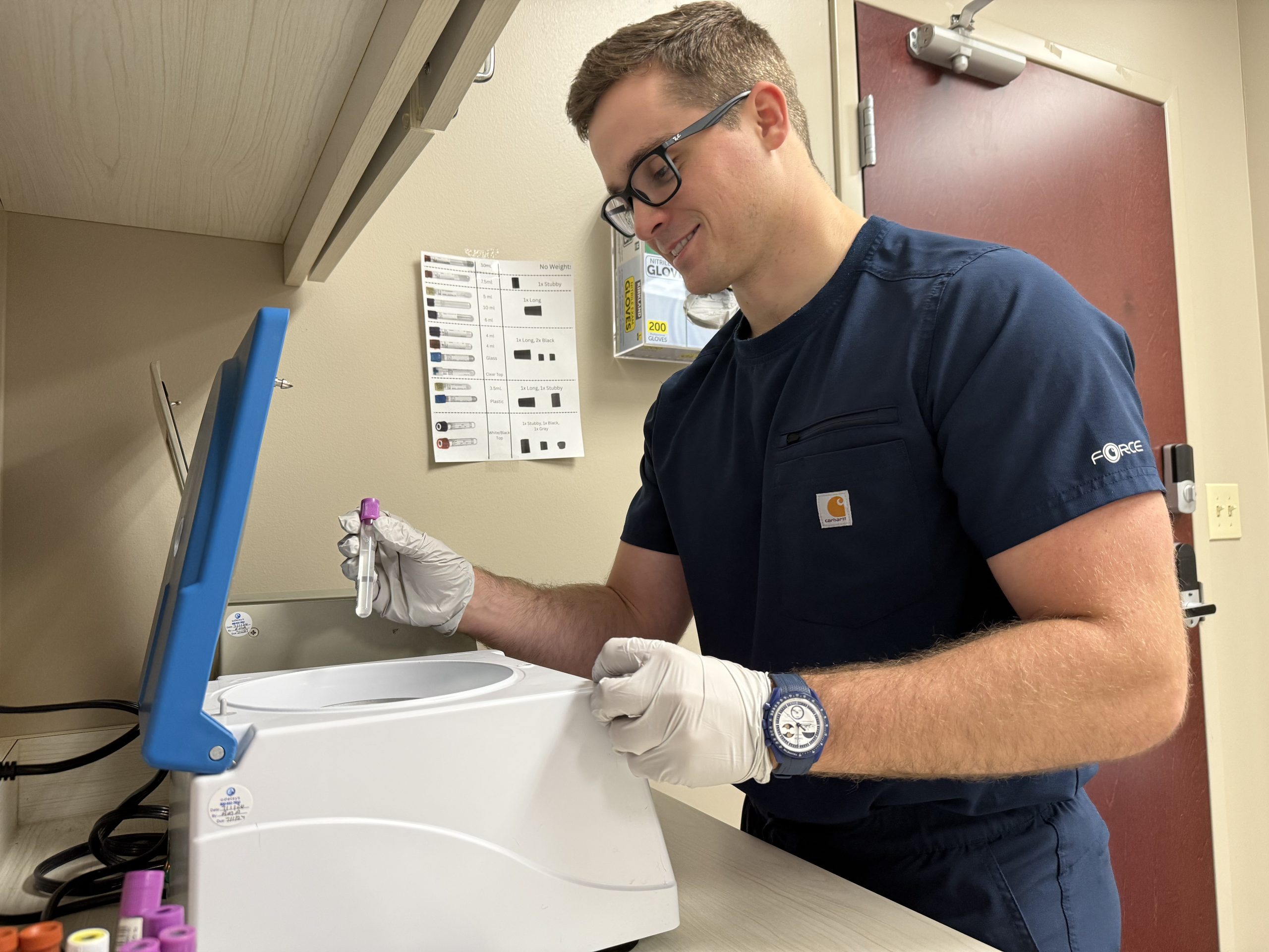 Ben Epting loading samples into a centrifuge at a research site